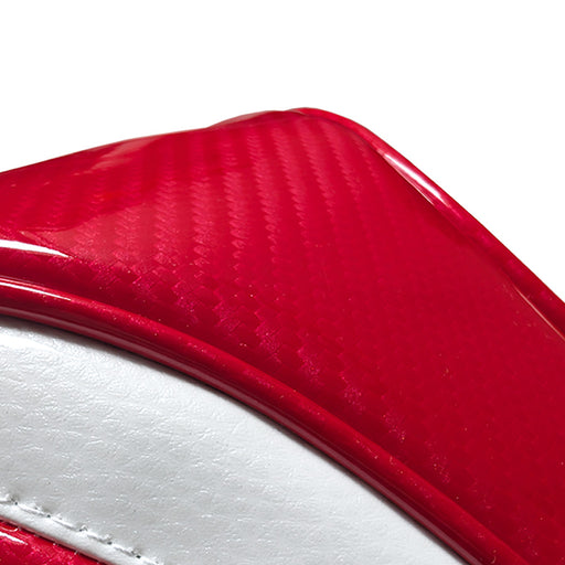 Close-up of a red, white, and black golf headcover with textured carbon fibre pattern